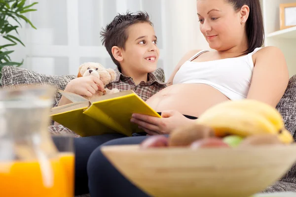 Zwangere moeder lezen boek een gelukkig kind — Stockfoto