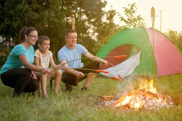 Familjen på en camping resa, far, mor och son bakning sausa — Stockfoto