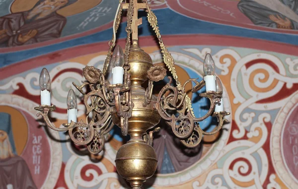Chandelier against the background of images of saints — Stock Photo, Image