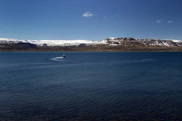 Atlantische oceaan landschap met kleine boot en bergen. Westfjorden, IJsland. — Stockfoto