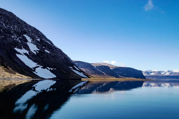 Lindas montanhas com neve e reflexo no oceano Atlântico. Westfjords, Islândia. — Fotografia de Stock