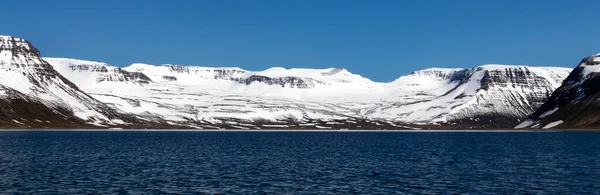 Vackra berg med snö plockar och turkost vatten i Atlanten. Westfjords, Island. Horisontell banderoll. — Stockfoto