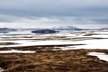 Thingvallavatn Gölü İzlanda 'daki Thingvellir Ulusal Parkı' nda. Kardaki dağlar, güzel göl ve suyun üzerindeki yansıma. Turistlerin ilgi odağı Altın Çember. Peyzaj arkaplanı.