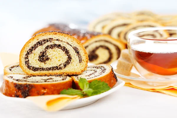 Macro of poppy seed roll slices and tea — Stock Photo, Image