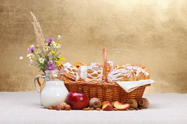 Süße Kuchen im Korb, Obst und Milchdekoration — Stockfoto