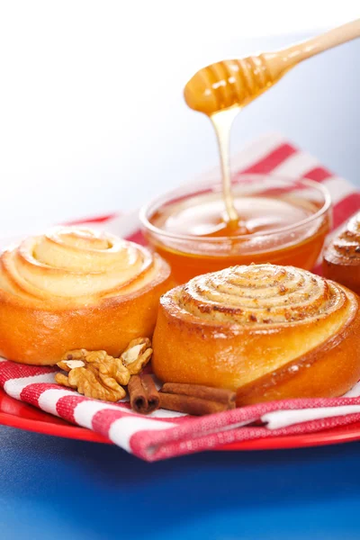 Заливая мёд свежими булочками с корицей — стоковое фото