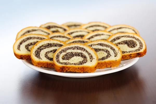 Slices of poppy seed rolls on plate — Stock Photo, Image