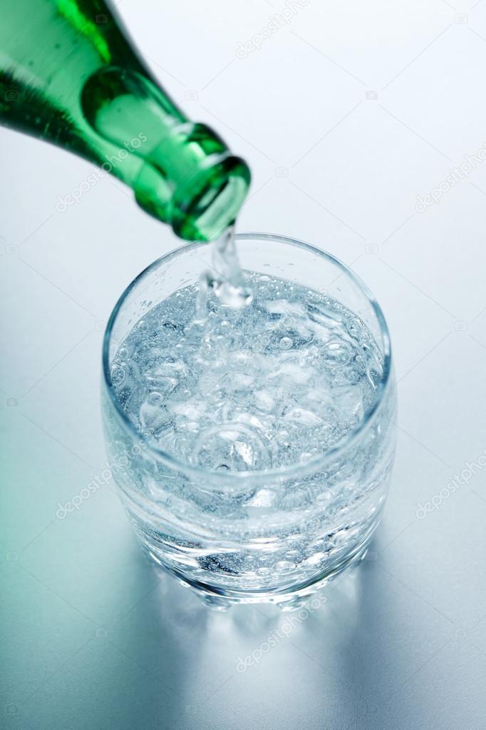 Mineral water pouring into glass