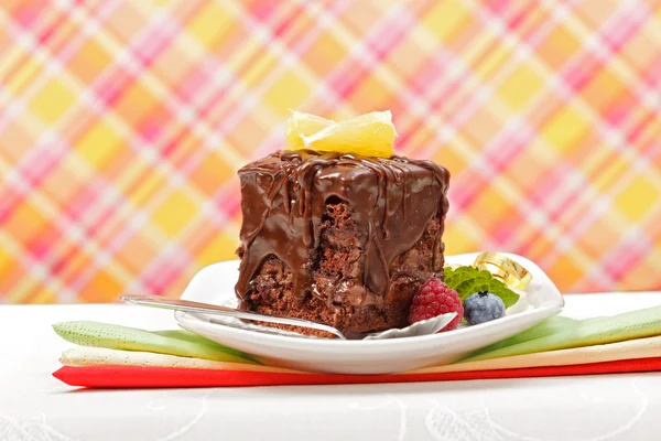 Торт с шоколадным блеском на тарелке — стоковое фото