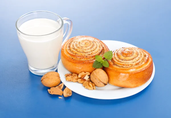 Dos rollos de canela y una taza de leche —  Fotos de Stock