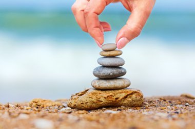 hand placng de laatste pebble van een gestapelde toren