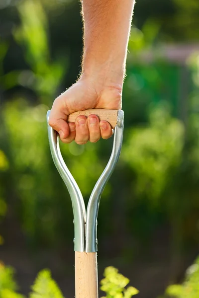 Hand pushing down spade — Stock Photo, Image