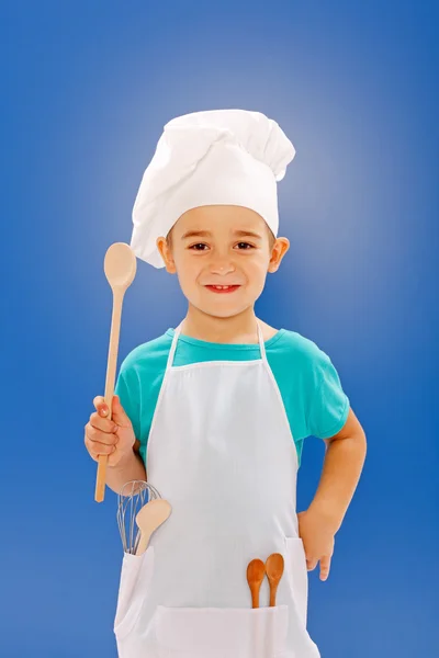 Little chef showing wooden spoon — Stock Photo, Image