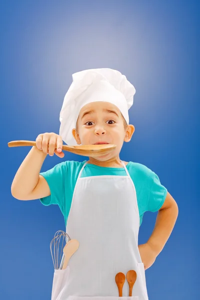 Little chef tasting food — Stock Photo, Image