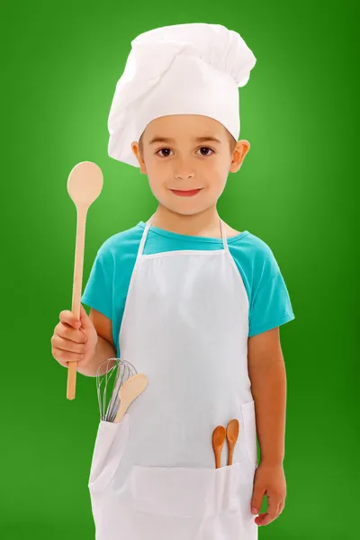 Little chef showing wooden spoon — Stock Photo, Image