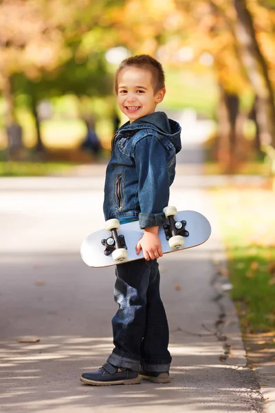 Criança segurando skate — Fotografia de Stock