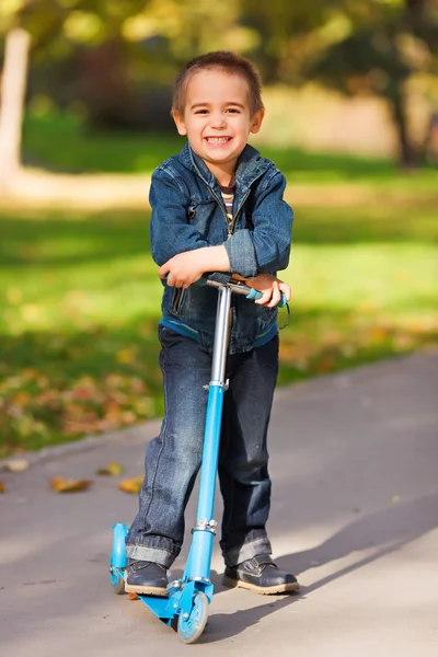Laughing boy with scooter — Stock Photo, Image