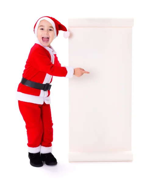 Little Santa Claus boy pointing at big wish list — Stock Photo, Image