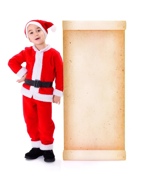 Little Santa Claus standing near big old paper wish list — Stock Photo, Image