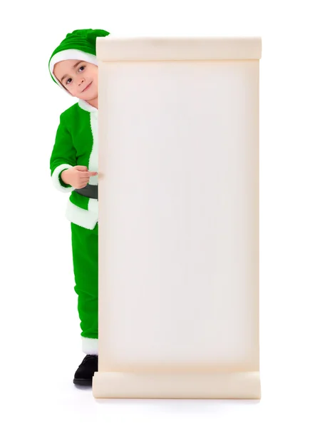 Little green Santa Claus boy pointing at big wish list