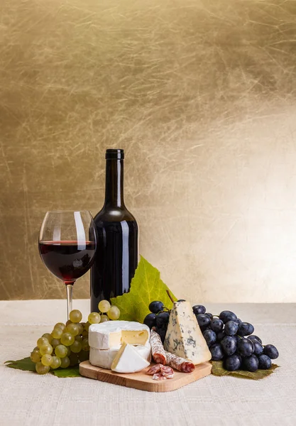 Vino tinto con queso y aperitivo de uva azul —  Fotos de Stock