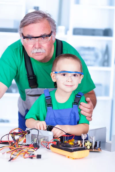 Avô orgulhoso com neto em oficina — Fotografia de Stock