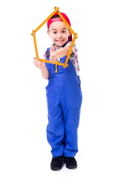 Chłopiec wyświetlane kciuki za pośrednictwem domu wykonane z pomiaru linijki — Zdjęcie stockowe