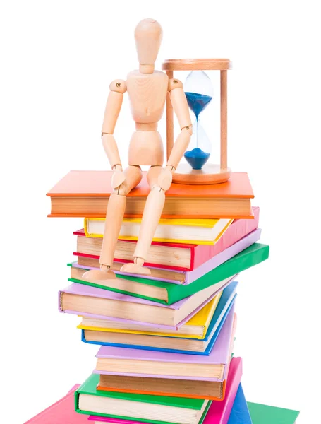 Wooden dummy puppet sitting on books — Stock Photo, Image