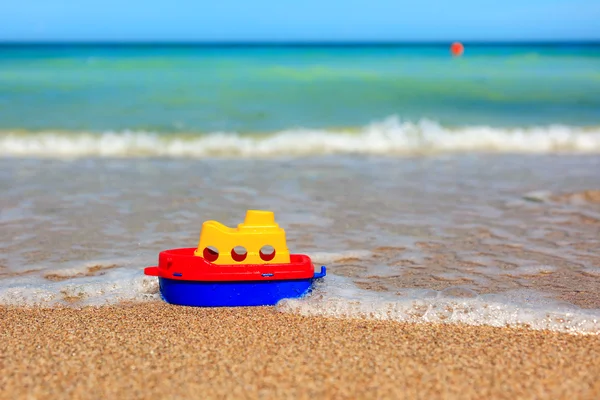 Kleines Spielzeugschiff am Strand — Stockfoto