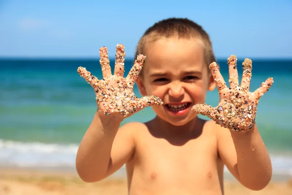 Petit garçon montrant des mains de sable — Photo