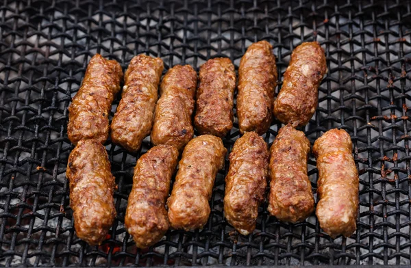 Rollos de carne rumana a la parrilla en la parrilla de barbacoa - mititei, mici —  Fotos de Stock