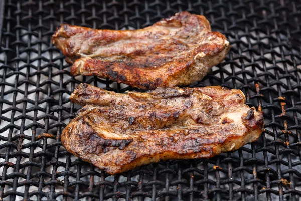 Fried meat slices on barbecue grid — Stock Photo, Image