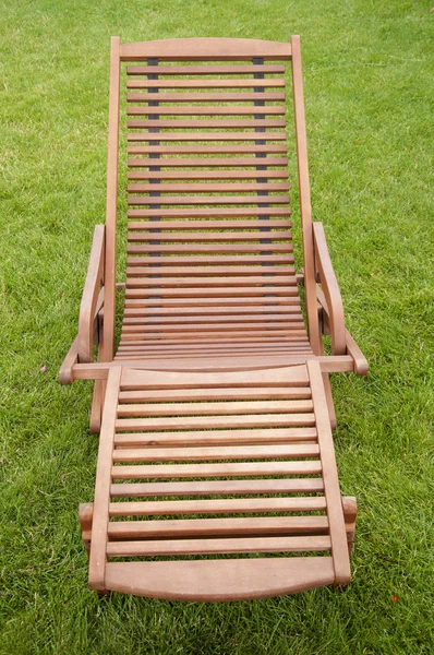 Dřevěné lehátko na zelené trávě — Stock fotografie