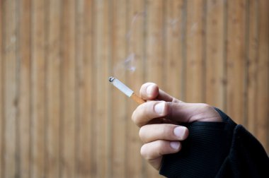 Bir adamın elinde yanan bir sigara