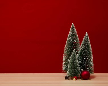 Noel ağacı kompozisyonu hediye kutusu ahşap bir masa duvarında kırmızı arka planda Noel mücevherleri. Yeni yıl için ya da yeni yıl tatili için boş alanınız için mutlu noeller metin için kopyalama alanı