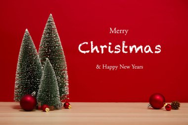 Noel ağacı kompozisyonu hediye kutusu ahşap bir masa duvarında kırmızı arka planda Noel mücevherleri. Yeni yıl için ya da yeni yıl tatili için boş alanınız için mutlu noeller metin için kopyalama alanı