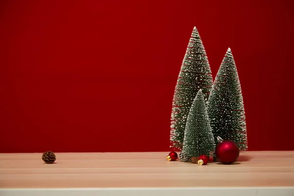 圣诞树构图礼品盒圣诞灯罩在木制桌墙的红色背景上 图库图片