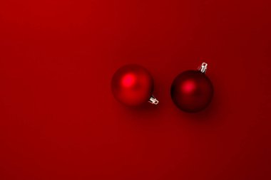 Kırmızı arka planda kırmızı noel topu süslemesi ve fotokopi alanı. Yeni yıl tebrik kartı. Asgari biçim