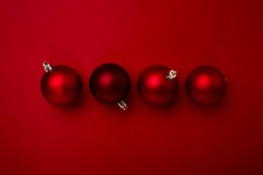 Kırmızı arka planda kırmızı noel topu süslemesi ve fotokopi alanı. Yeni yıl tebrik kartı. Asgari biçim