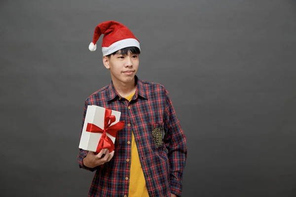 クリスマスパーティーや休日のコンセプト 若いアジア人がギフトボックスのスタジオショットを持って 灰色の背景に隔離された — ストック写真