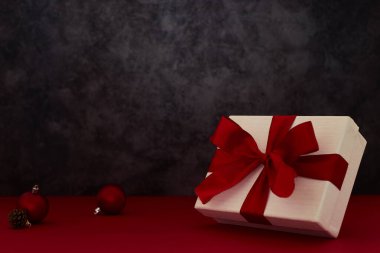 Kırmızı arka planda Noel hediyesi kutusu süslemesi olan kompozisyon