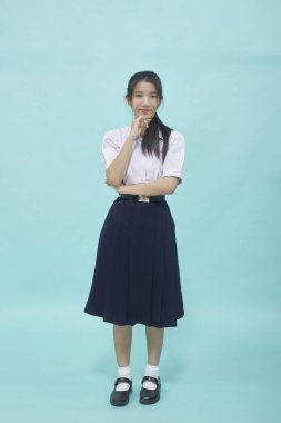 Açık mavi stüdyosundaki liseli kız öğrenci üniforması içinde izole edilmiş bir arka plan.
