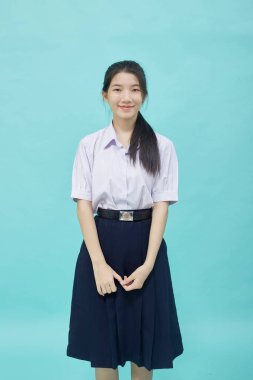 Açık mavi stüdyosundaki liseli kız öğrenci üniforması içinde izole edilmiş bir arka plan.
