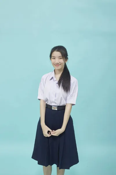 身穿学生服的年轻亚洲女生高中 背景浅蓝色 免版税图库图片