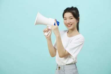 Portrait beautiful young woman smile with megaphone isolated over the blue background