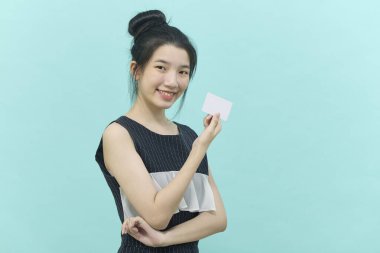 Genç, güzel Asyalı bir kadın gülümsüyor, gösteriyor, kredi kartı sunuyor.