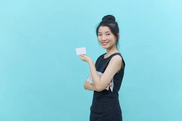 若い美しいアジアの女性は 青色の背景に支払いやオンラインビジネスを支払うためのクレジットカードを提示し — ストック写真