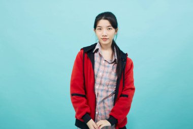 Kırmızı ceketli bir kadın. Stüdyo yaşam tarzına güvenen bir gülümseme.