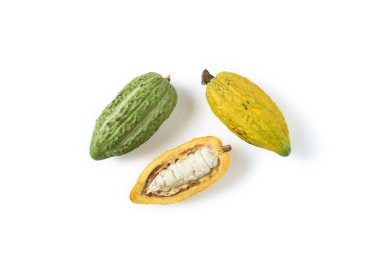 Sarı kakao kabuklarının üst görüntüsü ve beyaz arka planda yarım dilimlenmiş yeşil