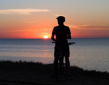 Baltık Denizi 'nde günbatımı bisikletçisi